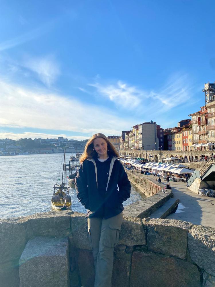 A student standing in front of buildings